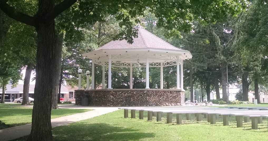 Park gazebo surrounded by trees and benches.