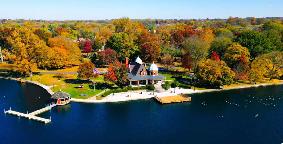 Autumn foliage at a lakeside park with gazebo.
