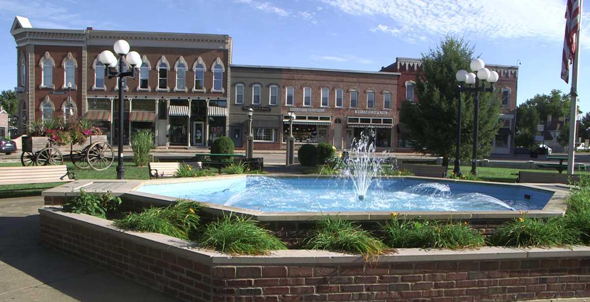 Downtown square with fountain and historic buildings.